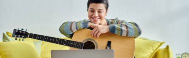 Online gitar dersi sırasında dizüstü bilgisayara gülümseyen neşeli kadın, evde eğitim, afiş