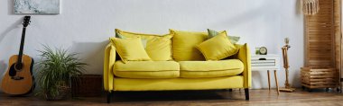 object photo of big yellow couch in vibrant spacious living room by wall with paintings, banner clipart