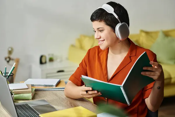 Stock image cheerful young woman with notebook and pen in hands looking happily at laptop camera, studying