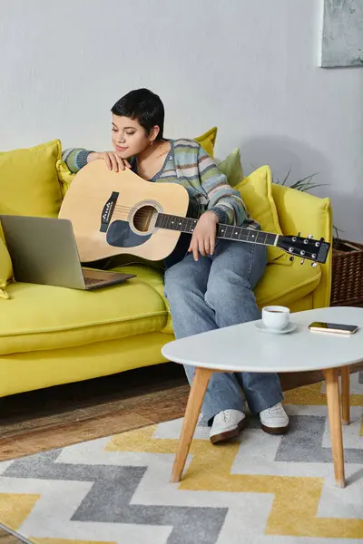 stock image vertical shot of cheerful young woman sitting on sofa with guitar on remote music lesson, education