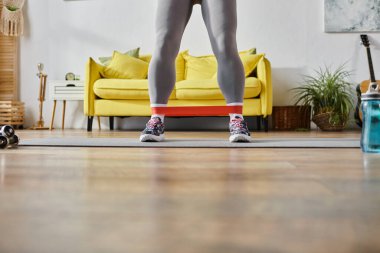 cropped view of young woman in sportswear exercising with resistance band, fitness and sport clipart