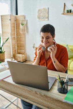 vertical shot of cheerful student in front of laptop attending online classes, education at home clipart