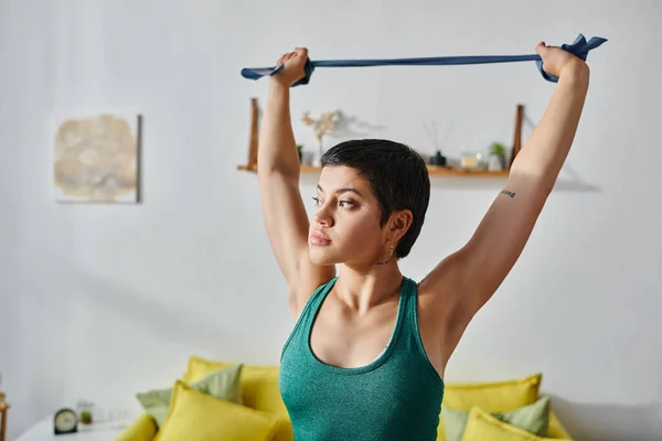 Attractive Short Haired Woman Tattoo Exercising Resistance Band Looking Away — Stock Photo, Image