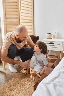 Güzel sakallı babanın sevimli oğluyla oynadığı dikey bir fotoğraf. Aile kavramı.