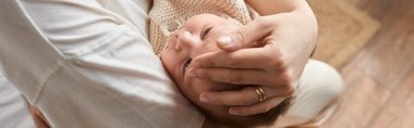 Sevimli yeni doğmuş erkek bebek annesinin kollarında huzur içinde yatıyor, elleri başının üstünde, aile kavramı, afiş