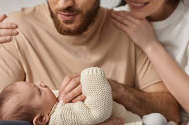 Sevimli ailesinin kollarında yatan yeni doğmuş bebek ve onlara bakmak, aile kavramı.