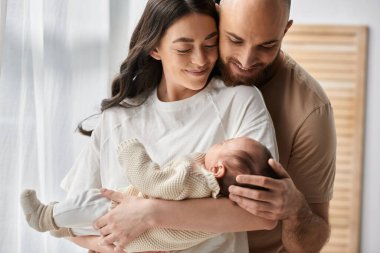 Güzel, mutlu ebeveynler yeni doğan erkek çocuklarını kucaklıyor ve kucaklıyor. Aile kavramı.
