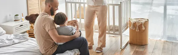 stock image young bearded father playing with his adorable little son next to his wife, family, banner