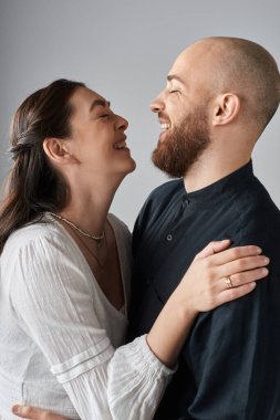 vertical shot of happy laughing couple hugging each other lovingly and smiling at each other clipart