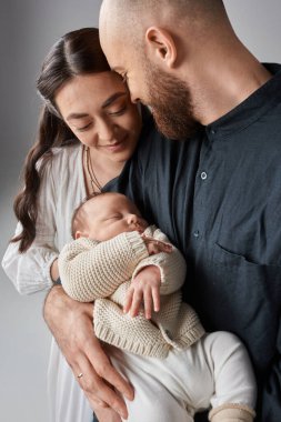 Sevgi dolu mutlu bir ailenin dikey görüntüsü. Yeni doğmuş tatlı erkek çocuklarına bakıyor. Modern ebeveynlik.