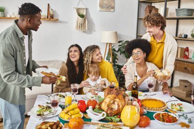 Thanksgiving traditions and joy, interracial friends and lgbt family gathering at table with turkey clipart