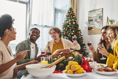 joyous multiethnic family having good time eating festive lunch with raised wine glasses, Christmas clipart