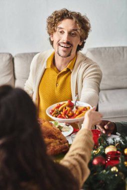 jolly man surrounded by his family at holiday lunch enjoying and sharing festive food, Christmas clipart