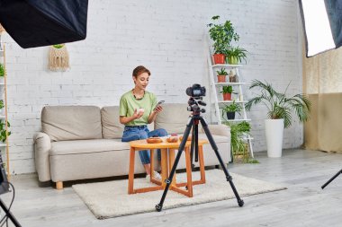 akıllı telefonlu video blogcusu vejetaryen yemek ve dijital kameralı evinde softbox lambası olan