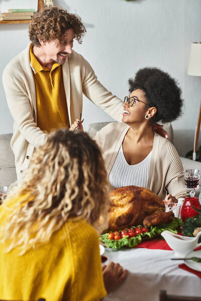 two family members looking and smiling at each other while sharing delicious food, Christmas