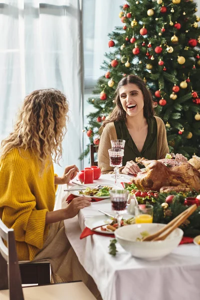 happy lgbt couple at family gathering looking and smiling cheerfully at each other, Christmas