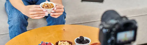 Stock image cropped woman with walnuts near vegetarian food and digital camera, vegetarian video blog, banner