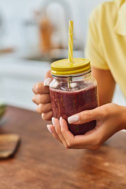 cropped view of woman with refreshing smoothie in mason jar with straw, plant-based diet concept clipart