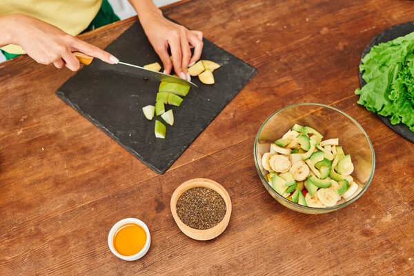 вид сверху на обрезанных женщин, готовящих фруктовый салат рядом с кунжутом семена и мед, вегетарианский рецепт