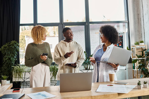 joyful team of friends in casual outfits discussing their project actively and cheerfully, business