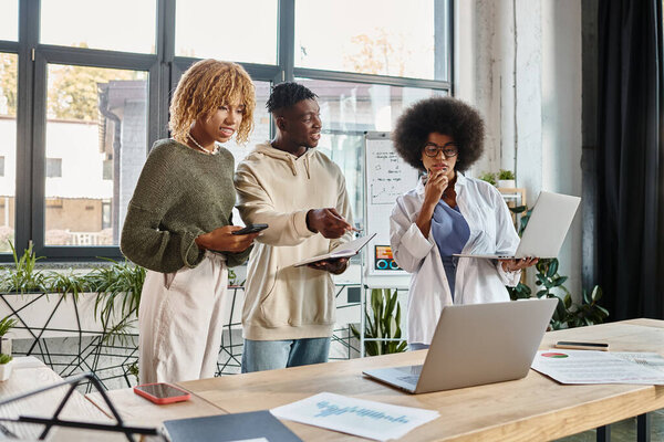 концентрированные друзья, работающие над своим проектом, указывая и жестикулируя активно, бизнес-концепция