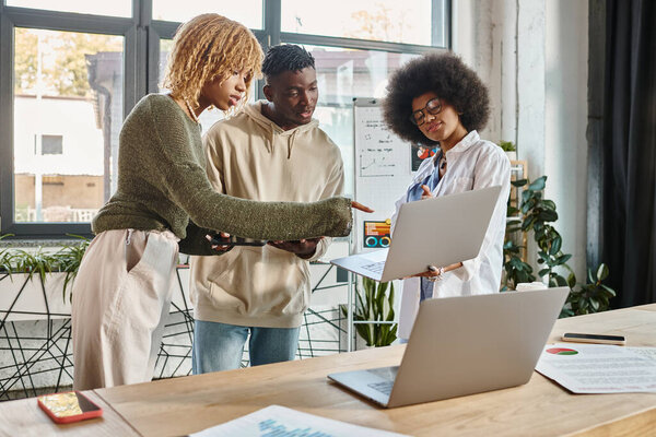team of focused young friends looking at laptops while working on their project, coworking concept