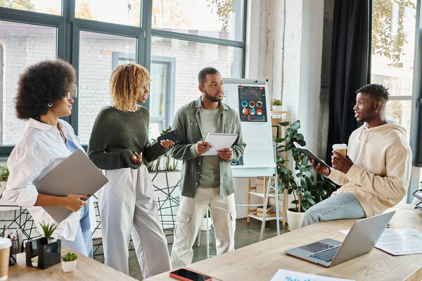 good looking friends discussing project with graphs on background and laptop on table, business