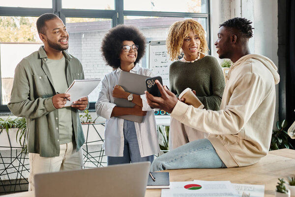 веселые молодые люди улыбаются и держа в руках ноты и чашки кофе, телефон в руке, бизнес-концепция