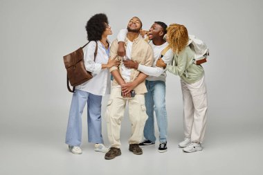 cheerful african american friends having good time posing on gray backdrop, student lifestyle clipart