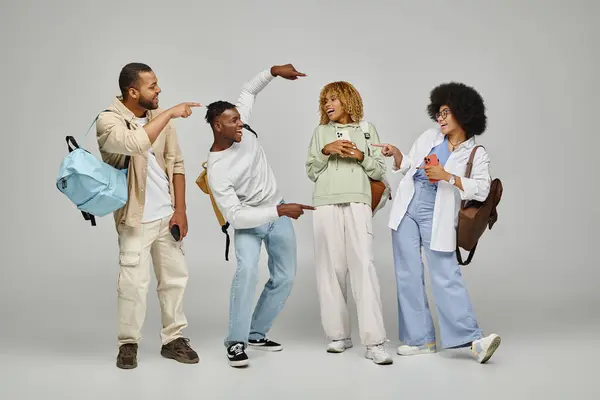 stock image happy laughing students in casual outfit with backpacks pointing fingers actively, studying concept