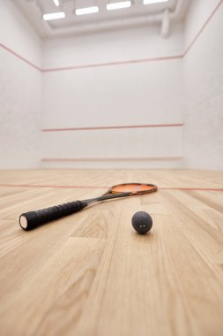 Beyaz duvarları, motivasyonu ve kararlılığı olan squash topu ve raketi mahkeme salonunda.