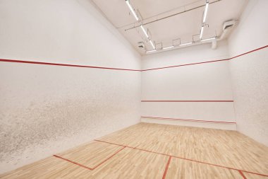 Beyaz duvarları ve cilalı zemini olan modern squash sahası, motivasyon ve kararlılık kavramı
