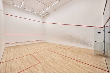 Beyaz duvarları ve cilalı zemini olan squash sahası, motivasyon ve kararlılık kavramı