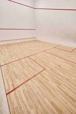Beyaz duvarları ve cilalı zemini olan modern squash salonu, motivasyon ve kararlılık kavramı