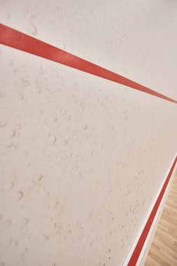Beyaz duvarları, kırmızı şeridi, motivasyonu ve kararlılığı olan modern squash salonu