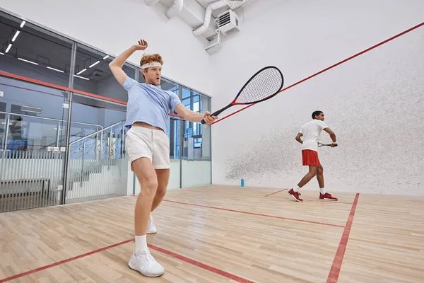 stock image interracial friends in sportswear playing squash together inside of court, motivation and sport