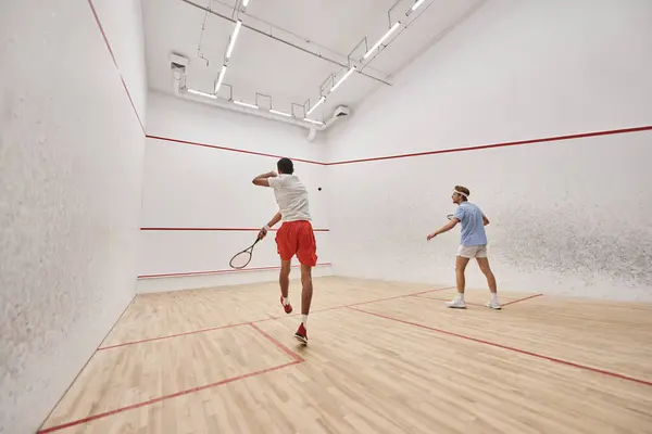 stock image interracial players in sportswear playing squash together inside of court, fitness and motivation