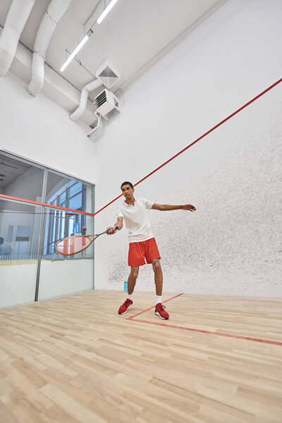 young african american sportsman playing squash inside of court, challenge and motivation