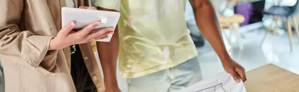 stock image cropped view of woman with digital tablet near african american colleague in print studio, banner