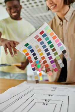 Baskı stüdyosunda çalışırken renkler paleti tutan bulanık ırklar arası moda tasarımcıları, takım çalışması