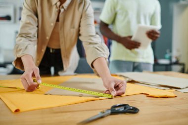 Baskı stüdyosunda kadın moda tasarımcısının dikiş kalıplarını ölçmesi, yaratıcı çalışma