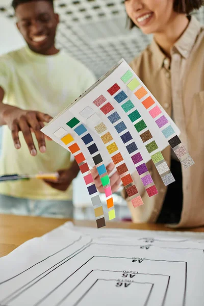 stock image blurred interracial fashion designers holding color palette while working in print studio, teamwork