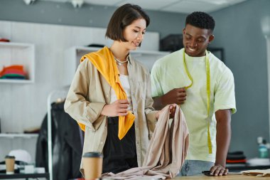 multiethnic designers with fabric samples and measuring tape working in print studio, small business clipart