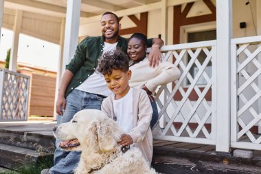 pozitif Afro-Amerikalı çocuk, ailesinin arka bahçesinde köpekle oynuyor, kaliteli zaman.