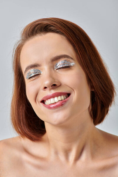 close up view of happy woman with holiday makeup and closed eyes, shiny eye shadow and red lipstick