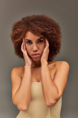 Pastel iç çamaşırlı güzel, Afro-Amerikan kadın. Yüzüne yakın elleri olan, moda anlayışı olan.