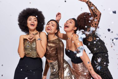 Güzel, şık Afro-Amerikan kadınları konfeti yağmuru ve moda altında canlı giysiler içinde parti yapıyorlar.