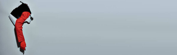 обрезанный баннер женщины с красным рукавом и разбитыми перчатками через отверстие в сером фоне, концепция