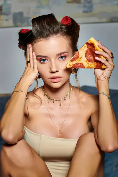 Stock image attractive sexy woman in alluring beige corset posing with slice of pizza and looking at camera