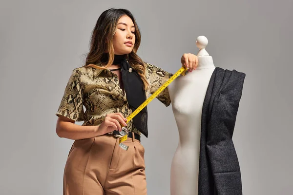 Cheerful Asian Fashion Stylist Holding Measuring Tape Mannequin Fabric Grey — Stock Photo, Image